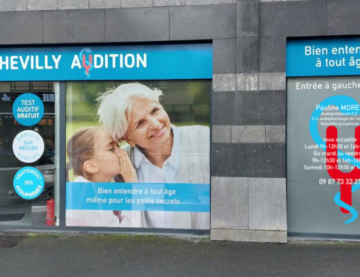 Devanture de « Chevilly Audition » avec visuels promotionnels. Une grande image montre une femme âgée souriante et une jeune fille. Un texte sur la porte propose des services de tests auditifs, avec coordonnées et horaires d'ouverture.